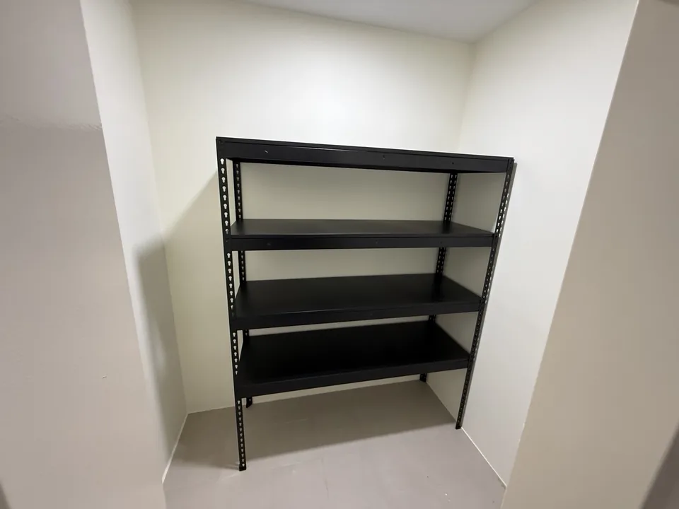 Single black four-tier rack fitted into a storeroom recess