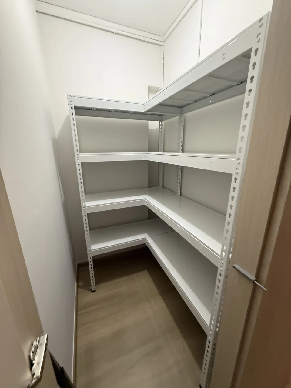 White L-shaped racks fitted into a narrow room with a clear central aisle